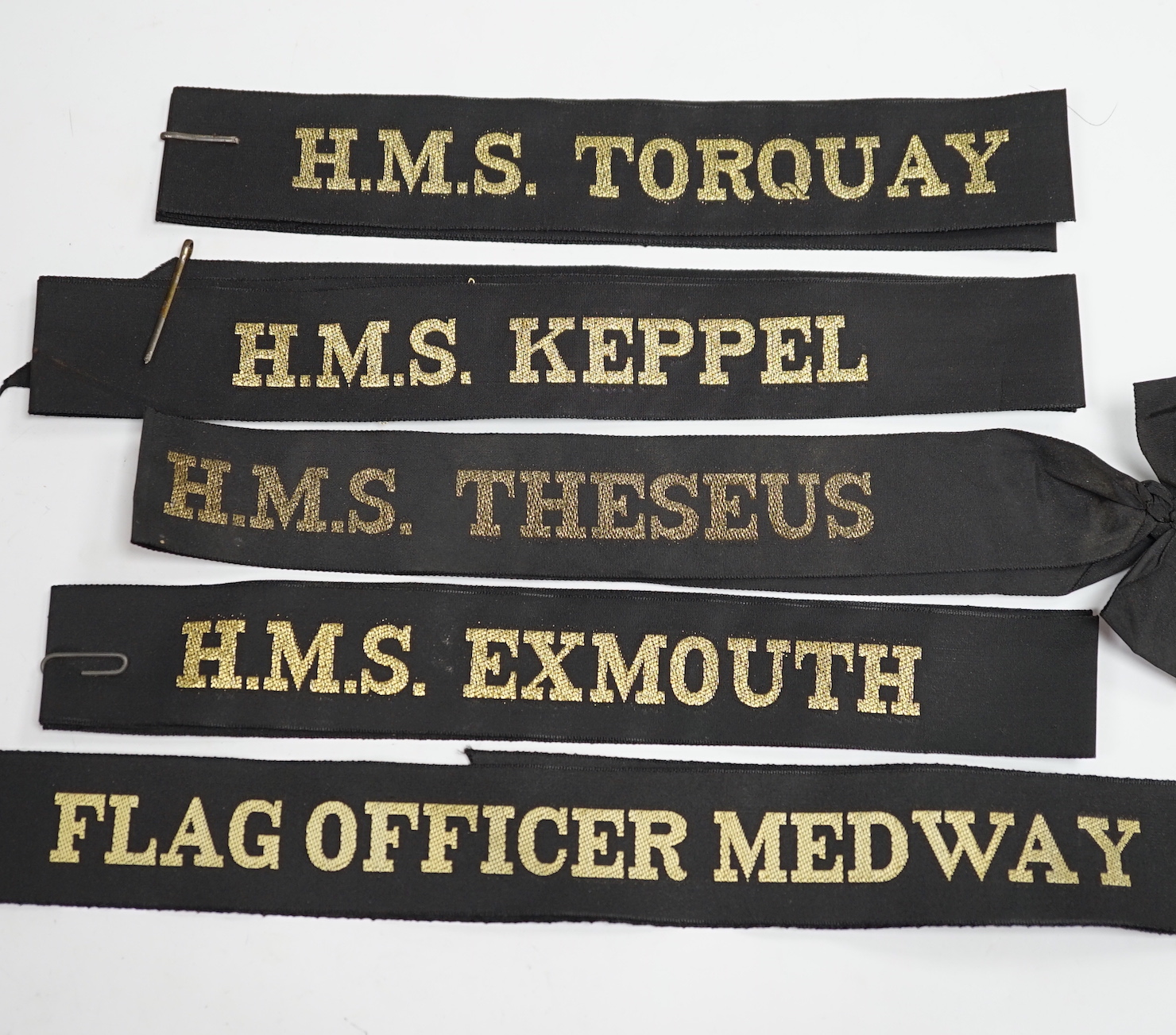 A collection of Royal Navy cap ribbons (tallies), including HMS Torquay, HMS Keppel, Commander Far East Fleet, HMS Danae, HMS Hardy, etc.